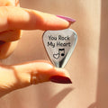 Close-up of personalized stainless steel guitar pick engraved with “You Rock My Heart” and music notes, ideal as a custom engraved gift for musicians, boyfriends, husbands, or dads on Father’s Day, anniversaries, weddings, or birthdays.