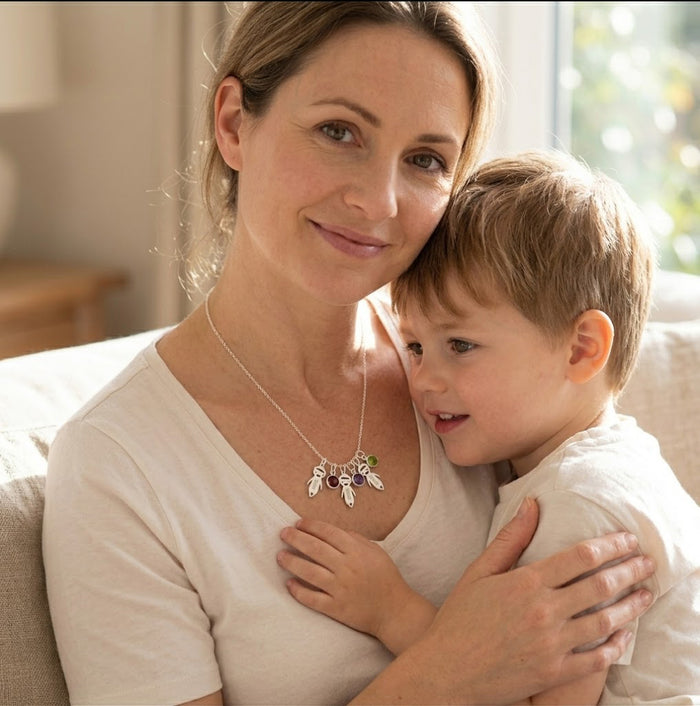 Mother and children wearing a custom family birthstone necklace with engraved child charms.