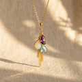 Personalized mom birthstone necklace with engraved vertical name bar charms on a warm neutral background.