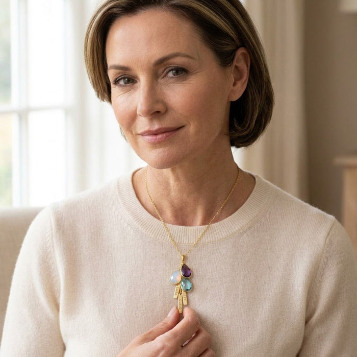 Mother’s necklace with multiple birthstones and engraved gold bar charms for children’s names.