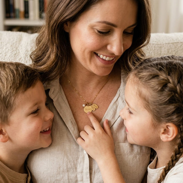 Mother wearing personalized family necklace with kids name charms