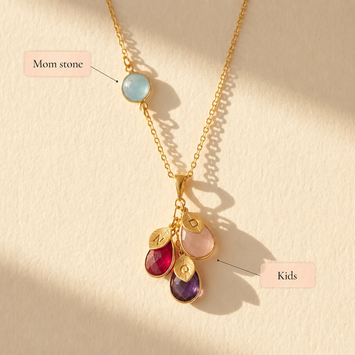 Custom mother’s birthstone necklace showing mom stone and kids’ teardrop stones, personalized family jewelry with engraved initial leaf charms.