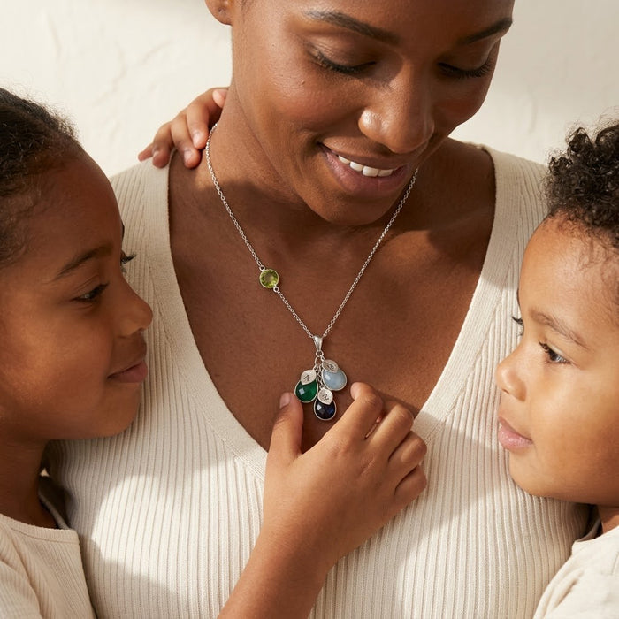 Mother wearing personalized birthstone necklace with children, a custom family necklace representing kids, grandchildren, or loved ones.