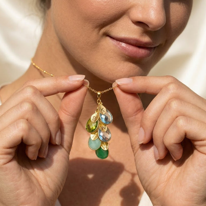 Model wearing custom mother’s birthstone necklace with cascading stones, personalized necklace for mom with children’s birthstones and initials.
