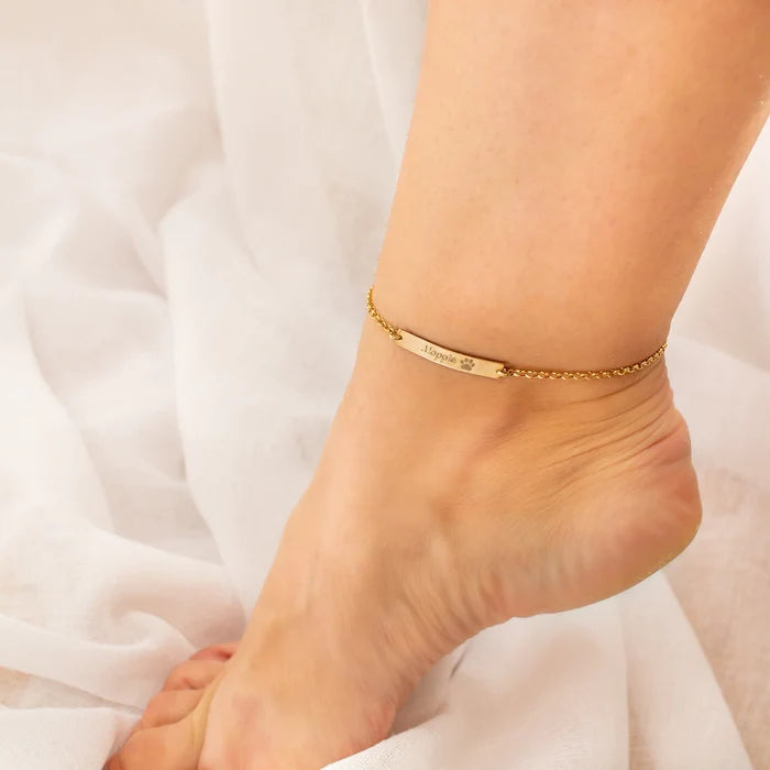 Gold-filled pet name bar anklet worn on a woman’s ankle with a delicate chain