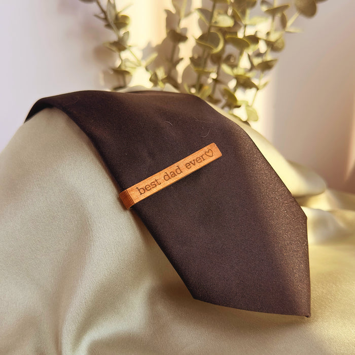 Mahogany wood tie clip with custom engraving best dad ever, placed on brown necktie. Rustic yet refined accessory, ideal as a groom or groomsmen gift, Father’s Day present, 5th anniversary wood gift, or graduation keepsake. Perfect for adding a personalized touch to men’s formal wear, business meetings, weddings, and special celebrations.