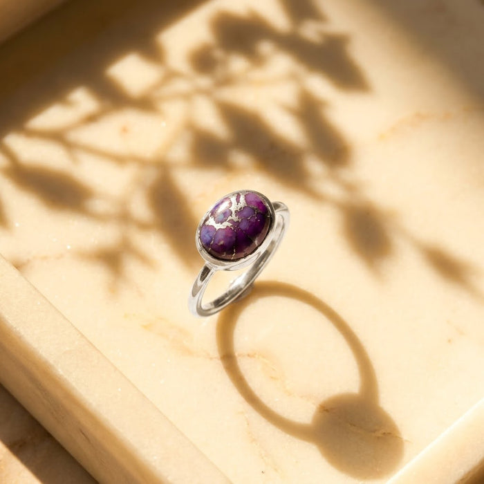 Side view of an oval purple copper turquoise ring in sterling silver