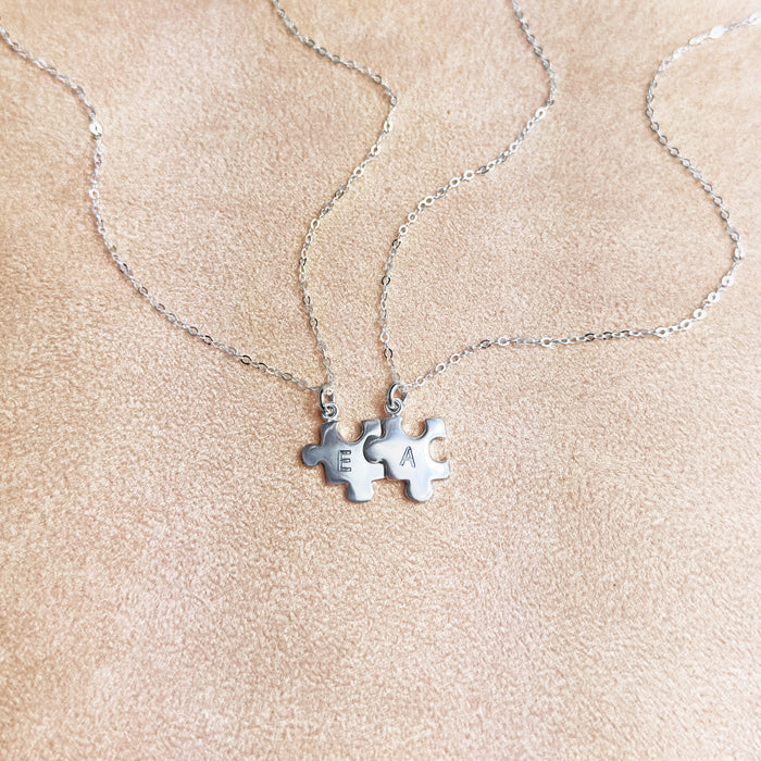 Silver puzzle charm necklace with A initial on beige background. sterling silver or vermeil gold, each charm features a single engraved initial. Whether it’s for your other half, your lifelong best friend, or a bond between mother and child, this necklace makes a meaningful gift for Christmas, Mother’s Day, or Valentine’s Day. layering necklace, puzzle piece, bff jewelry, couples jewelry, bff necklace, couples necklace