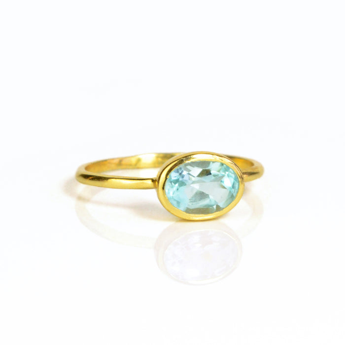 a gold blue topaz ring shown on white background. stackable! Stacking rings, bezel set, small oval, tiny oval, dainty oval, birthstone rings, sterling silver stamp, birthstone ring, birthstone jewelry, blue gemstone, blue birthstone, december birthstone, december gemstone
