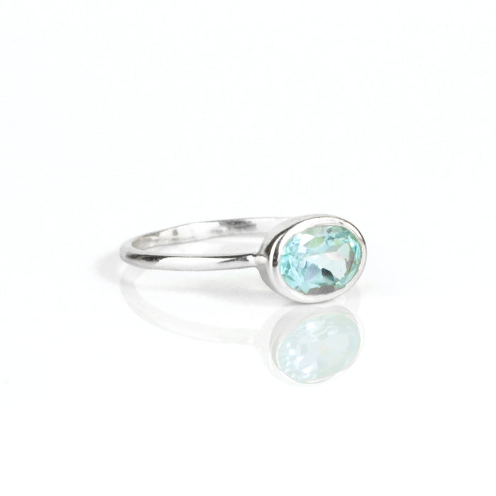 a sterling silver blue topaz ring shown on white background. stackable! Stacking rings, bezel set, small oval, tiny oval, dainty oval, birthstone rings, sterling silver stamp, birthstone ring, birthstone jewelry, blue gemstone, blue birthstone, december birthstone, december gemstone