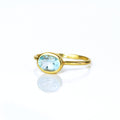 a gold blue topaz ring shown on white background. stackable! Stacking rings, bezel set, small oval, tiny oval, dainty oval, birthstone rings, sterling silver stamp, birthstone ring, birthstone jewelry, blue gemstone, blue birthstone, december birthstone, december gemstone