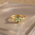a gold green amethyst ring shown on beige background. green gemstone, green birthstone, february birthstone, february gemstone, stack set, stacking rings, gemstone ring, birthstone ring, mother's day gift for her, gift for mom, gift for fiance, gift for girlfriend, wedding jewelry, bridesmaid jewelry, anniversary jewelry, anniversary gift, birthday gift, christmas gift, valentine's day gift, valentine's day rings, dainty ring, cocktail ring, statement ring, bezel set