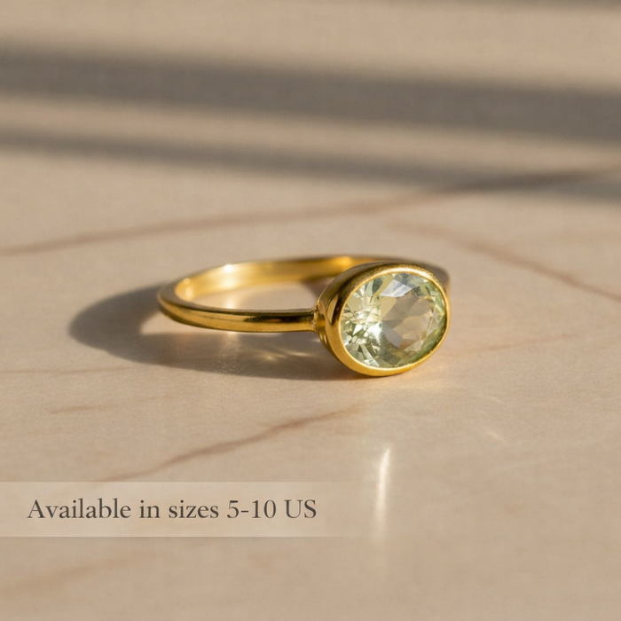 Small oval green amethyst bezel ring photographed from the side, highlighting the smooth setting and delicate band. Minimalist prasiolite gemstone ring designed for stacking or wearing alone. Handmade February birthstone jewelry available in sterling silver and gold vermeil finishes.