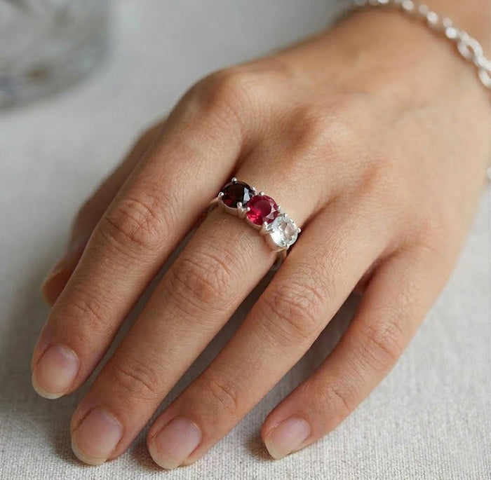 Custom three birthstone ring for mom in gold, dainty family gemstone ring on white background