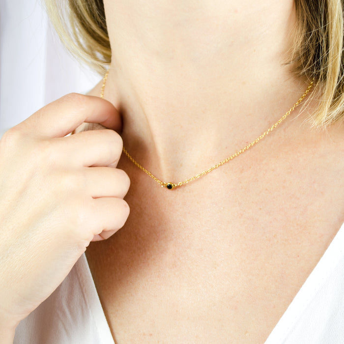 Model in white top is wearing a gold filled dainty 3mm connector necklace with black onyx birthstone.