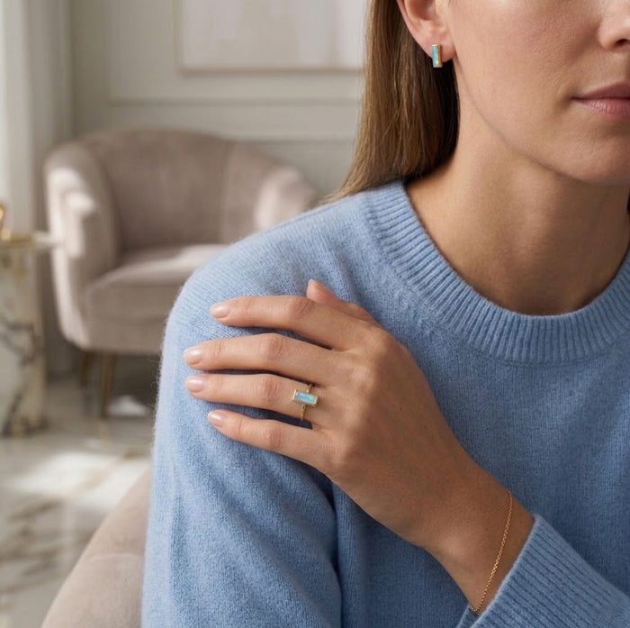Moonstone ring styled on model hand with delicate gold band and June birthstone.