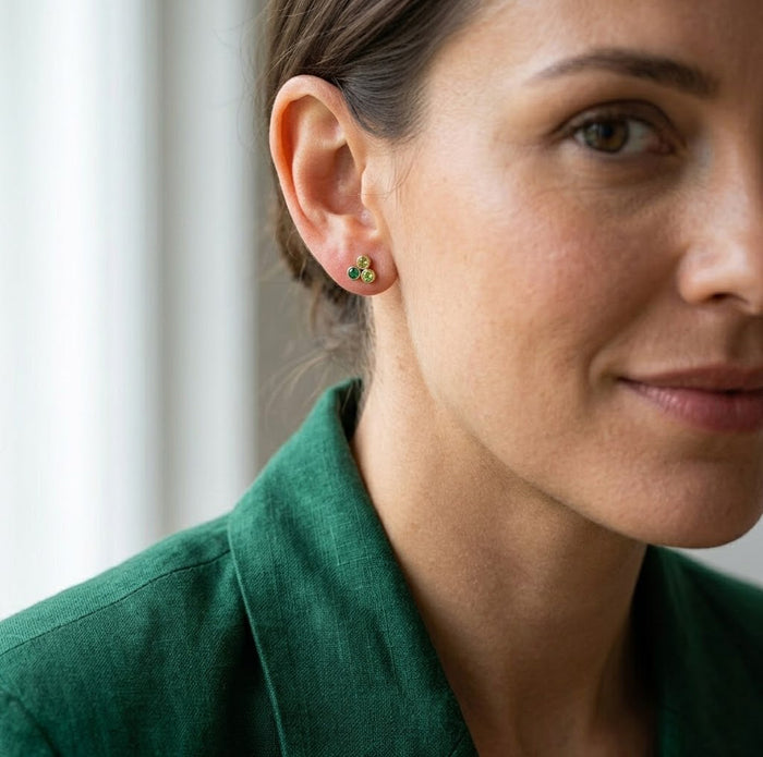 Dainty triple birthstone earrings shown on model, a minimalist personalized jewelry gift for mom or grandma.