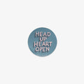 Round vinyl sticker with 'Head Up Heart Open' text on a light blue background
