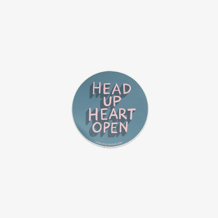 Round vinyl sticker with 'Head Up Heart Open' text on a light blue background
