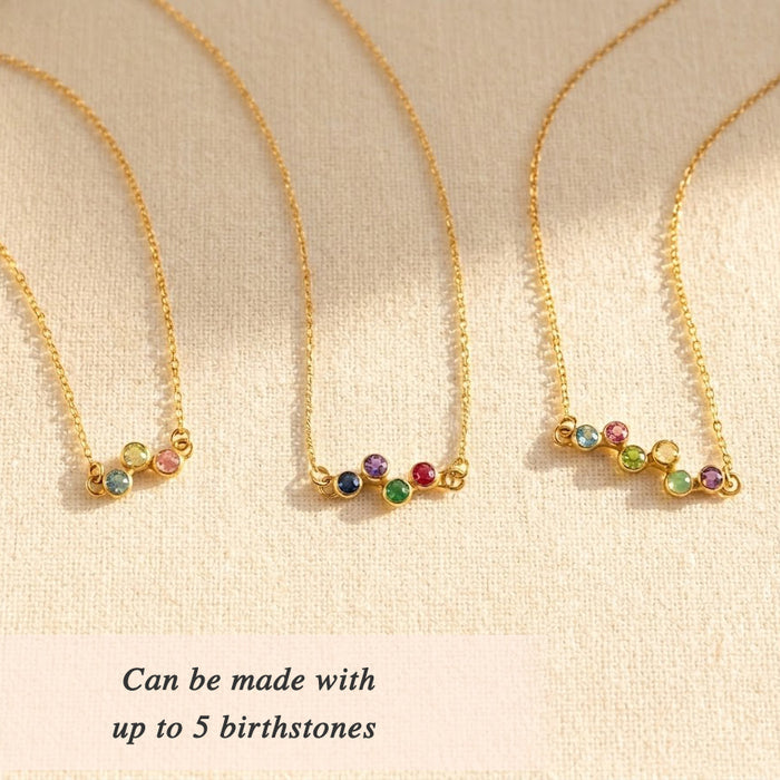 Minimalist birthstone necklace with festive colorful gemstones arranged in a graceful curved zigzag design.